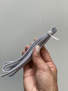DIY-Idee: Quasten für Lenker des Velos, Schritt 2: Schnürsenkel falten und mit Schnur / Band zusammenbinden