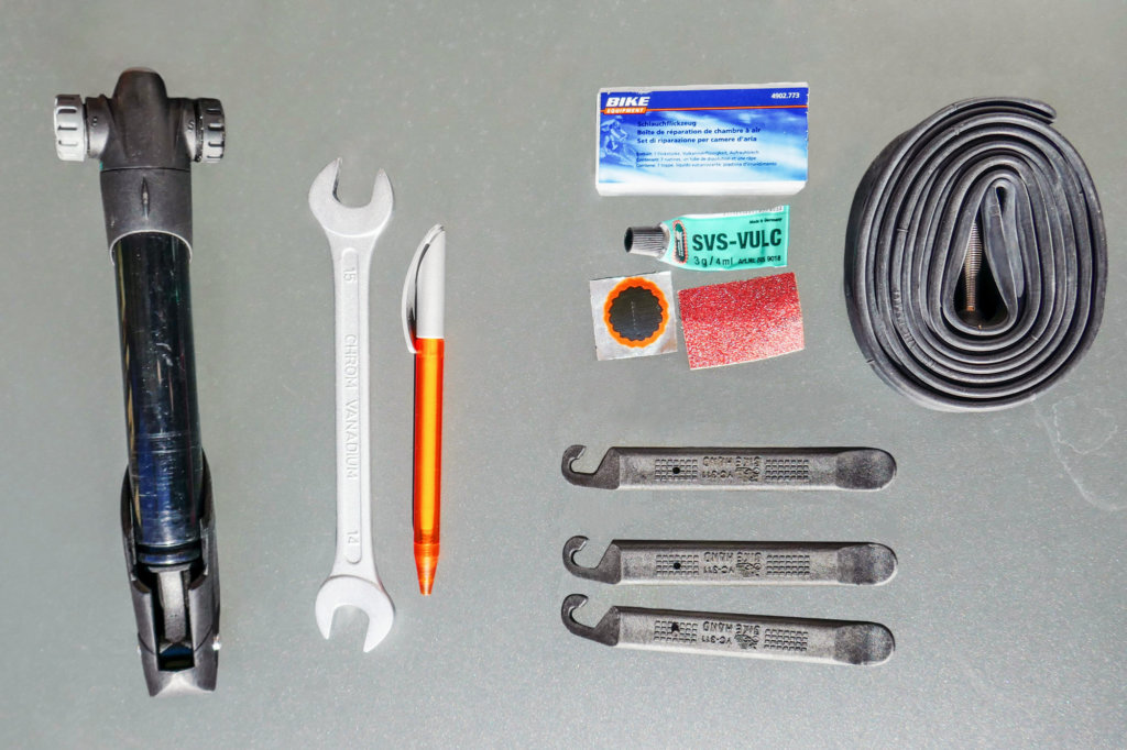 pompe, clé (taille 15), stylo à bille, kit de réparation, chambre à air si nécessaire